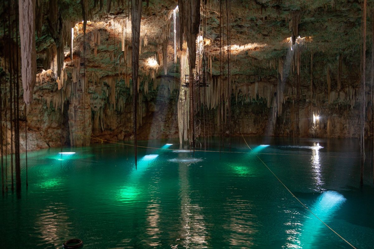 Cenote con agua verde turquesa y estalactitas en la península de Yucatán, México